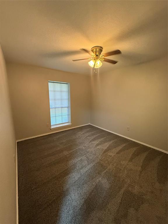 304 East Hickory Street, Unit A Kaufman, TX 75142 - Photo 12 of 12 an empty room with windows and fan