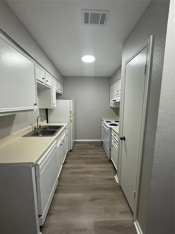 a kitchen with granite countertop a sink and cabinets
