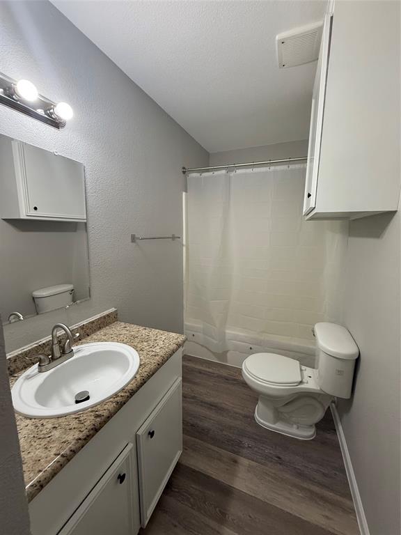 304 East Hickory Street, Unit A Kaufman, TX 75142 - Photo 10 of 12 a bathroom with a sink toilet a mirror and vanity