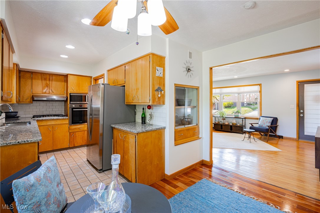 Kitchen with tasteful backsplash, stainless steel appliances, sink, and light hardwood / wood-style floors