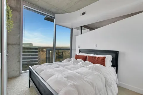 a bedroom with a large bed and a balcony view