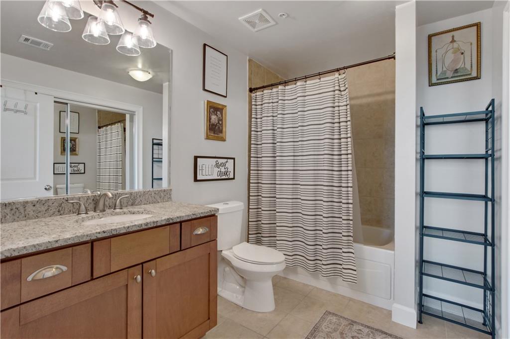 3300 Windy Ridge Parkway Southeast, Unit 1603 Atlanta, GA 30339 - Photo 21 of 39 a bathroom with a granite countertop sink toilet and shower