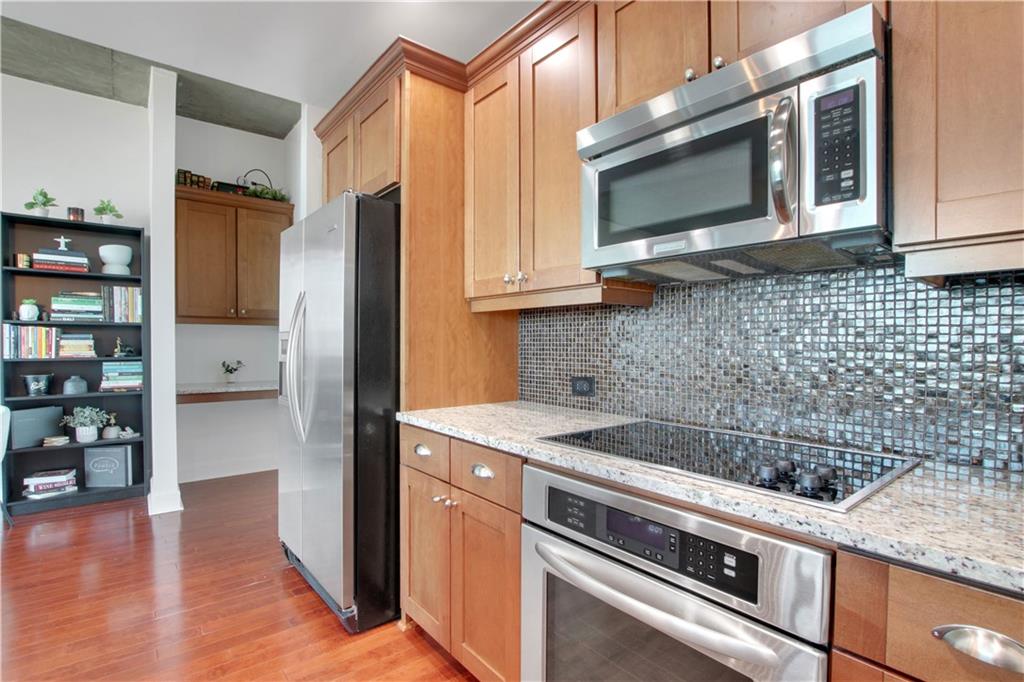 3300 Windy Ridge Parkway Southeast, Unit 1603 Atlanta, GA 30339 - Photo 6 of 39 a kitchen with stainless steel appliances granite countertop a stove microwave and refrigerator