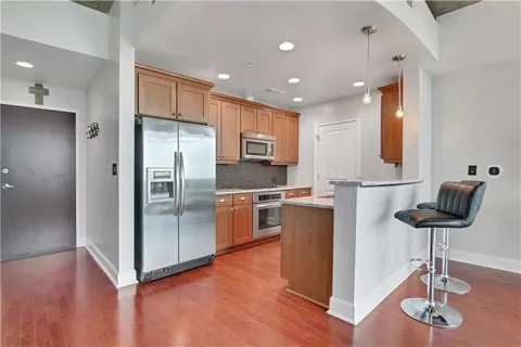 a kitchen with stainless steel appliances kitchen island granite countertop a refrigerator and a stove top oven