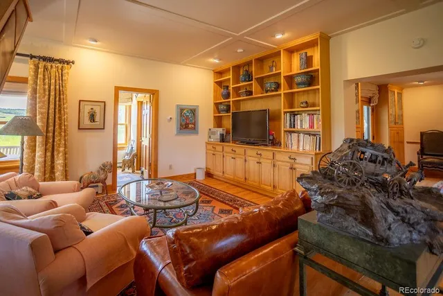 a living room with furniture a lamp and large window