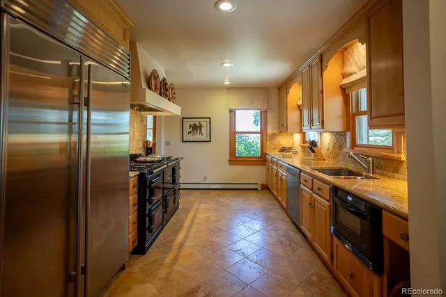 a kitchen with stainless steel appliances granite countertop a refrigerator and a sink