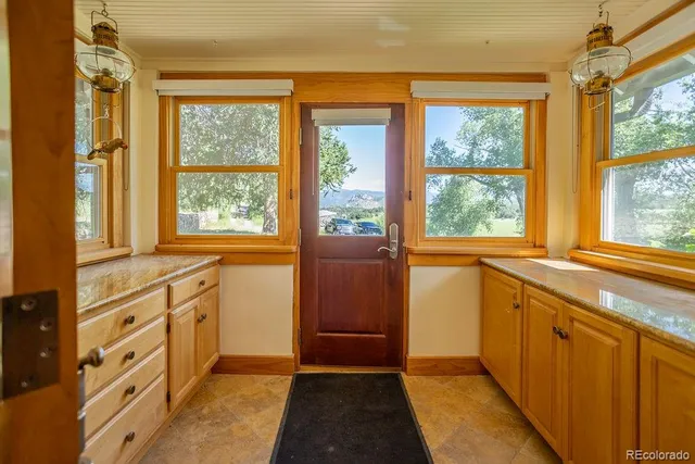 a kitchen with granite countertop a refrigerator a sink and windows