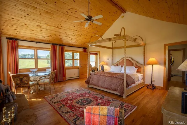 a bedroom with bed and wooden floor