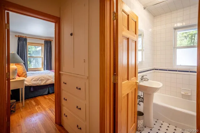 a bathroom with a tub sink and mirror
