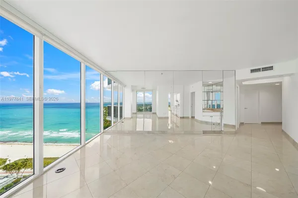 a view of empty room with floor to ceiling window and an outdoor kitchen