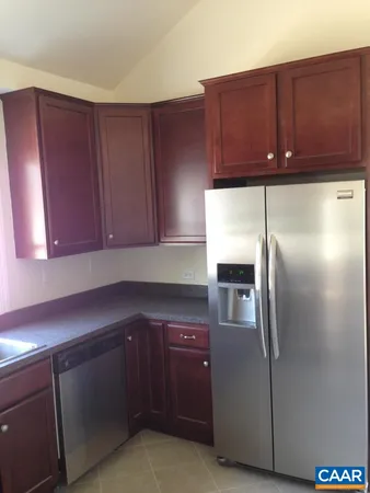 a kitchen with stainless steel appliances granite countertop wood cabinets and granite counter tops