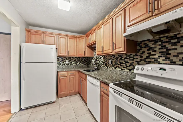 a kitchen with a refrigerator a stove a sink and cabinets