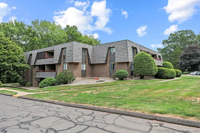 a front view of a house with a yard and trees