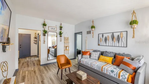 a living room with furniture and a wooden floor