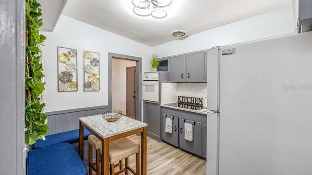 a kitchen with stainless steel appliances granite countertop a stove a refrigerator and a dining table