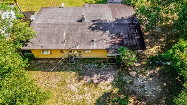 an aerial view of a house with a yard and large tree