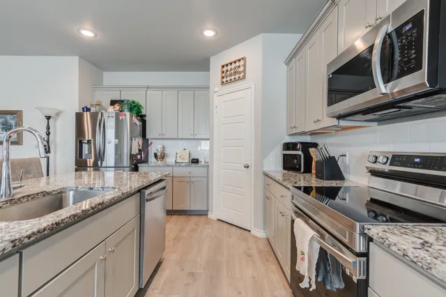 a kitchen with stainless steel appliances granite countertop a sink and cabinets
