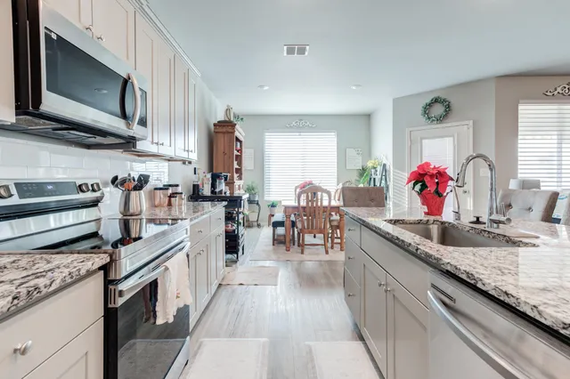 a kitchen with stainless steel appliances granite countertop a stove and cabinets