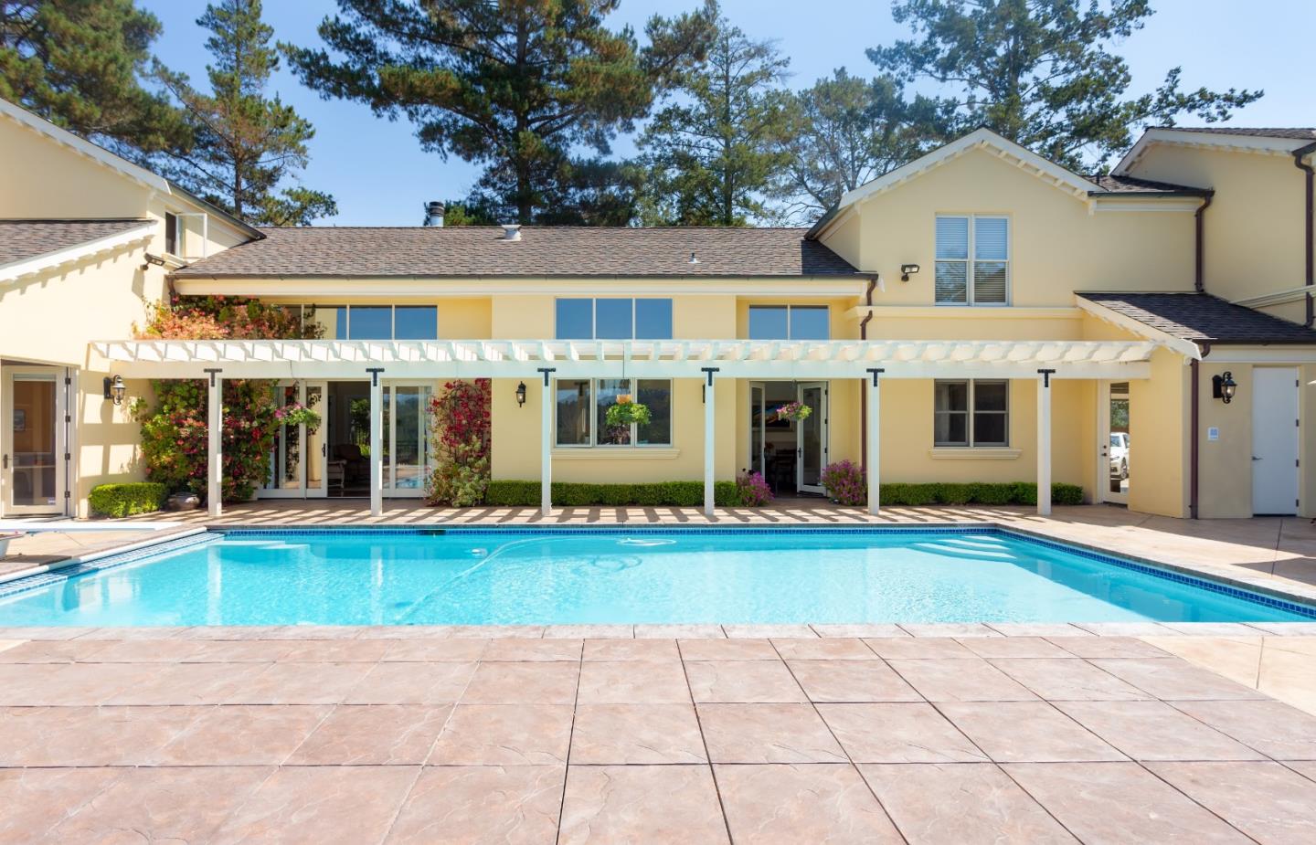 595 Day Valley Road Aptos, CA 95003 - Photo 2 of 37 a view of a white house with a large windows and a yard with plants and large trees