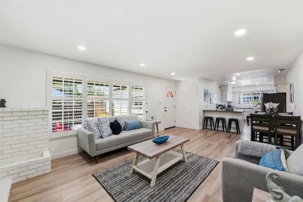 a living room with furniture wooden floor and a large window