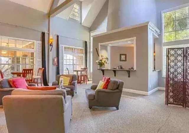 a living room with furniture and a floor to ceiling window