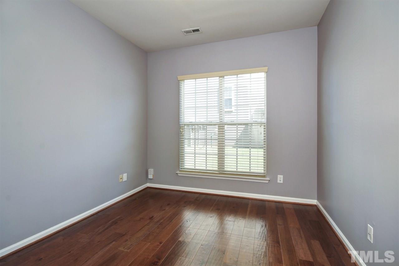 7444 Lagrange Drive Raleigh, NC 27613 - Photo 13 of 30 an empty room with wooden floor and windows