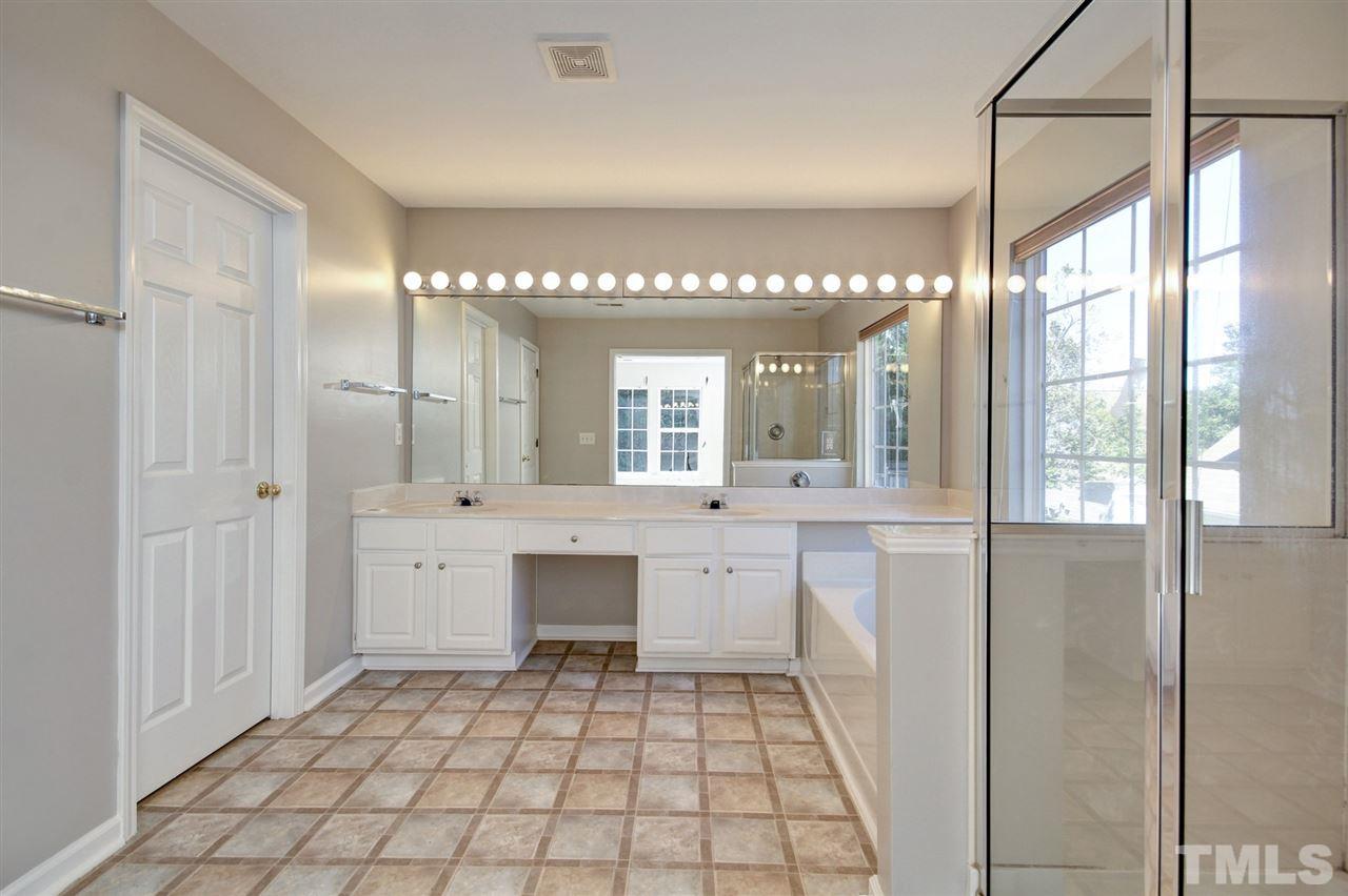 7444 Lagrange Drive Raleigh, NC 27613 - Photo 18 of 30 a bathroom with a sink a mirror and a bathtub in shower