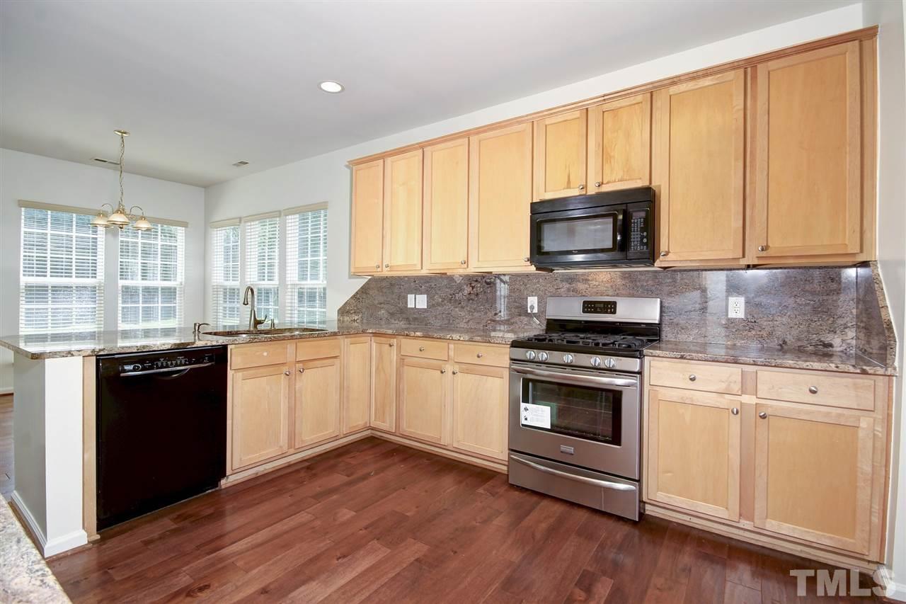 7444 Lagrange Drive Raleigh, NC 27613 - Photo 7 of 30 a kitchen with granite countertop a stove top oven microwave and cabinets