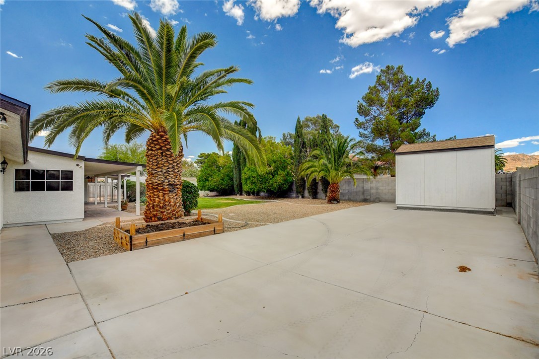 1810 Pinto Road Henderson, NV 89002 - Photo 51 of 53 A spacious concrete patio and vibrant landscaping create a welcoming outdoor haven.