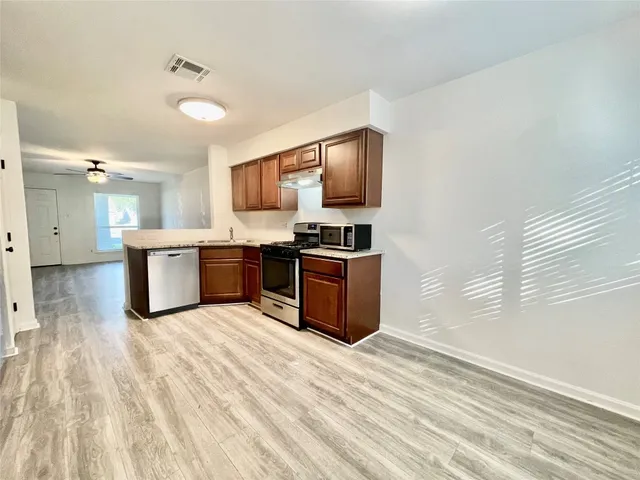 a kitchen with stainless steel appliances granite countertop a stove top oven and sink