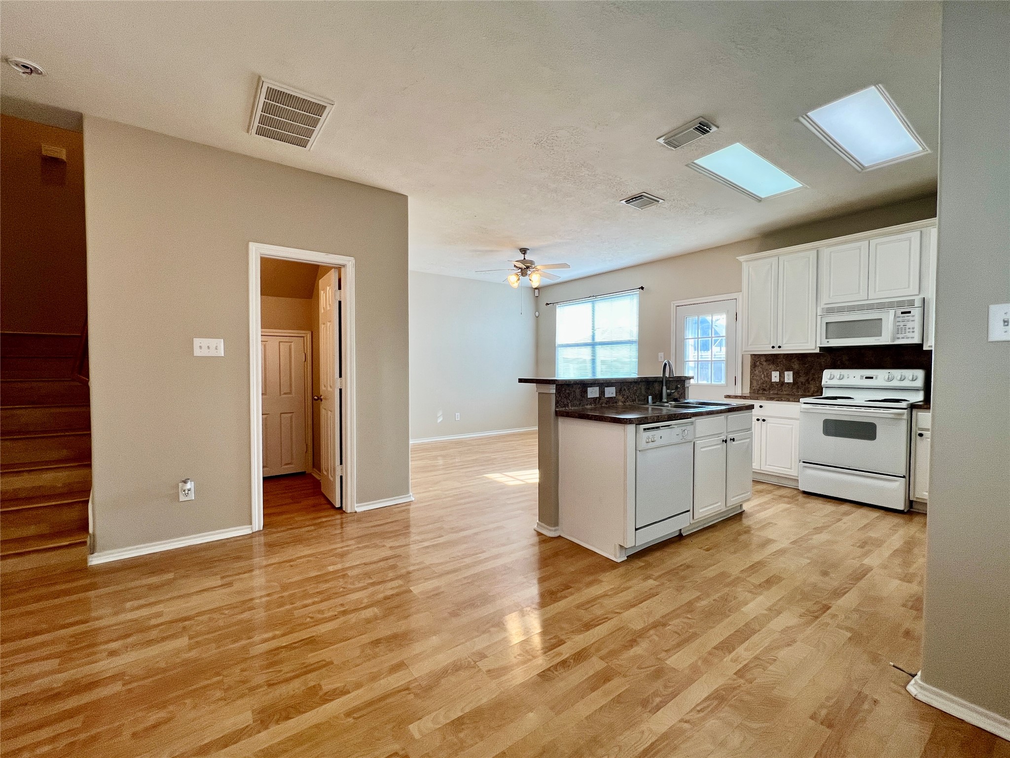 11834 Ramla Place Trail Houston, TX 77089 - Photo 4 of 30 a large white kitchen with granite countertop a stove top oven a sink and white cabinets