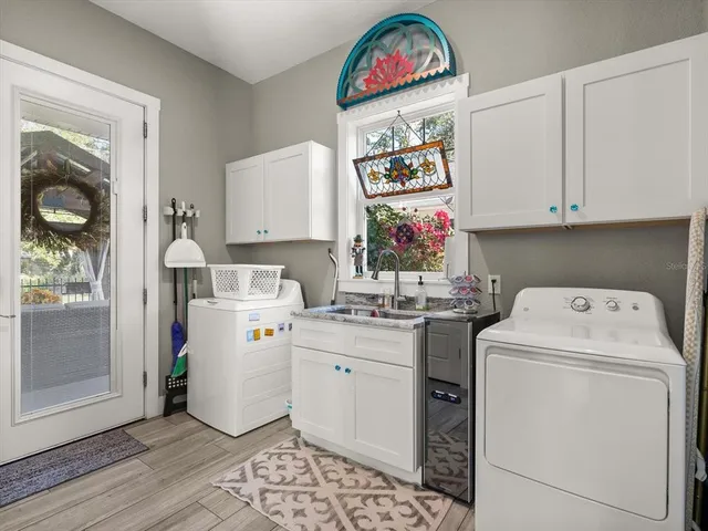 a utility room with fridge dryer and washer
