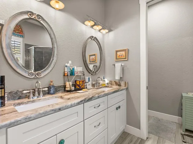 a bathroom with a granite countertop double vanity sinks and a mirror