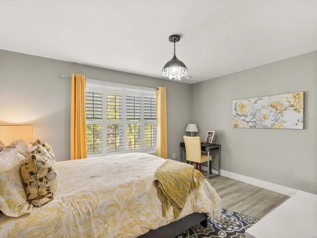 a bedroom with a large bed and a chandelier