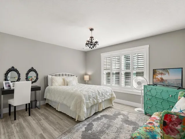 a bedroom with a bed and a dresser next to a window
