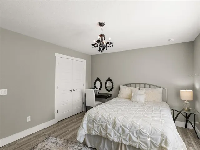 a bedroom with a bed and a chandelier