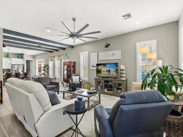a living room with furniture a fireplace and a chandelier