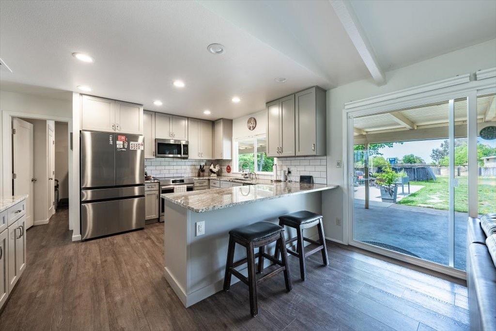 14066 Skyview Road Madera, CA 93636 - Photo 8 of 42 a kitchen with refrigerator a island and chairs in it