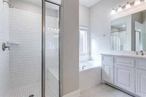 a bathroom with a double vanity sink mirror and bathtub
