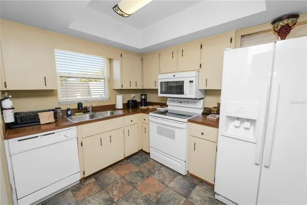 a kitchen with white cabinets and white appliances