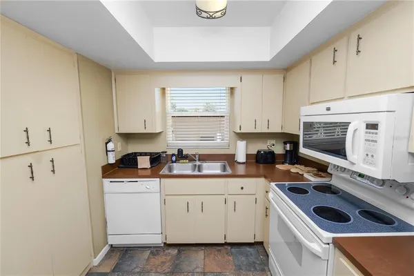 a kitchen with white cabinets sink and white appliances