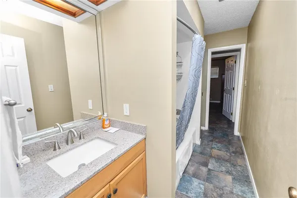 a bathroom with a sink vanity granite and a mirror