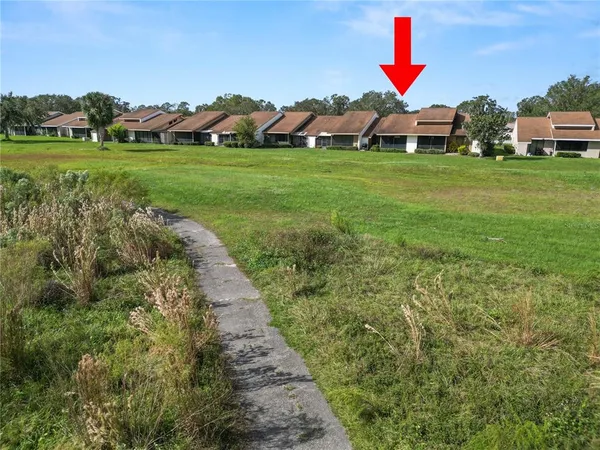 a view of an and white house with a yard and potted plants