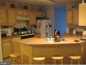 148 Barracuda Road Manahawkin, NJ 08050 - Photo 5 of 8 a kitchen with stainless steel appliances granite countertop a sink a stove and a refrigerator