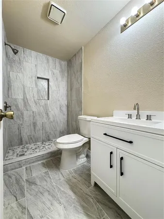 a bathroom with a sink a toilet and shower