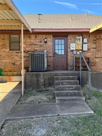 a view of a house with a small yard and wooden floor and fence