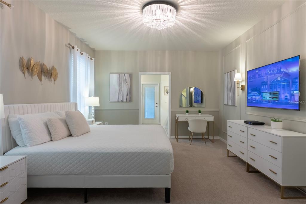 4425 Kaipo Road Davenport, FL 33897 - Photo 26 of 100 a bedroom with a large bed and a chandelier