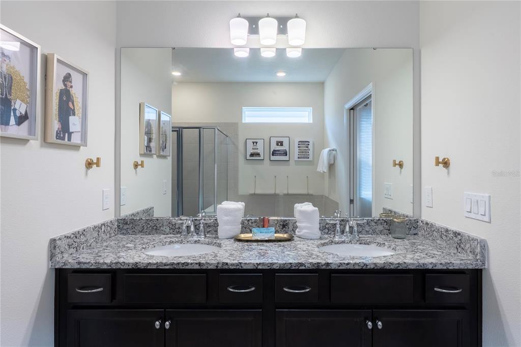 4425 Kaipo Road Davenport, FL 33897 - Photo 32 of 100 a bathroom with a granite countertop sink and a mirror