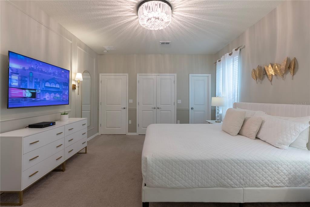 4425 Kaipo Road Davenport, FL 33897 - Photo 33 of 100 a bedroom with a bed and a chandelier