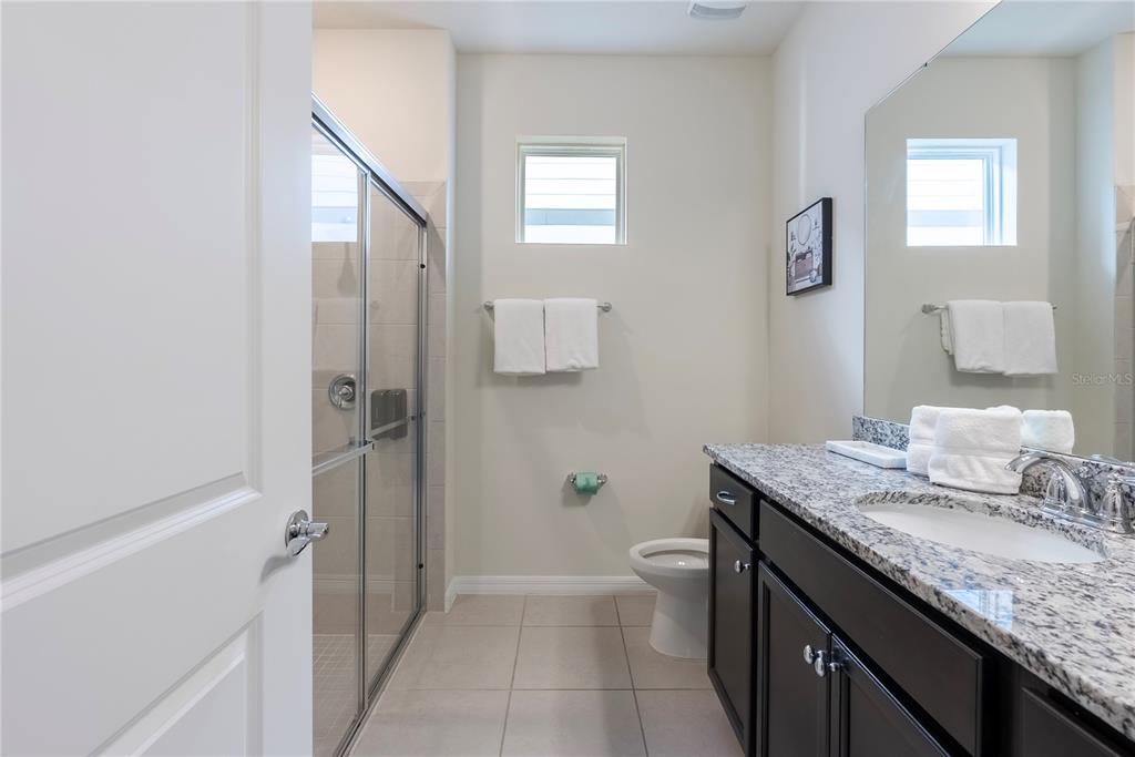 4425 Kaipo Road Davenport, FL 33897 - Photo 5 of 100 a bathroom with a granite countertop sink a toilet and shower